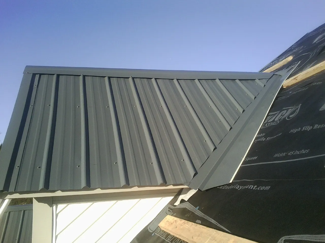 Gray metal roof panels going on over a garage gable in Rosburg