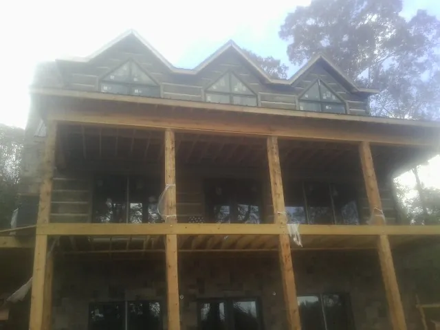 Dormers and porch framing on a large log home under construction — Roof Coating work by our crew in Rosburg